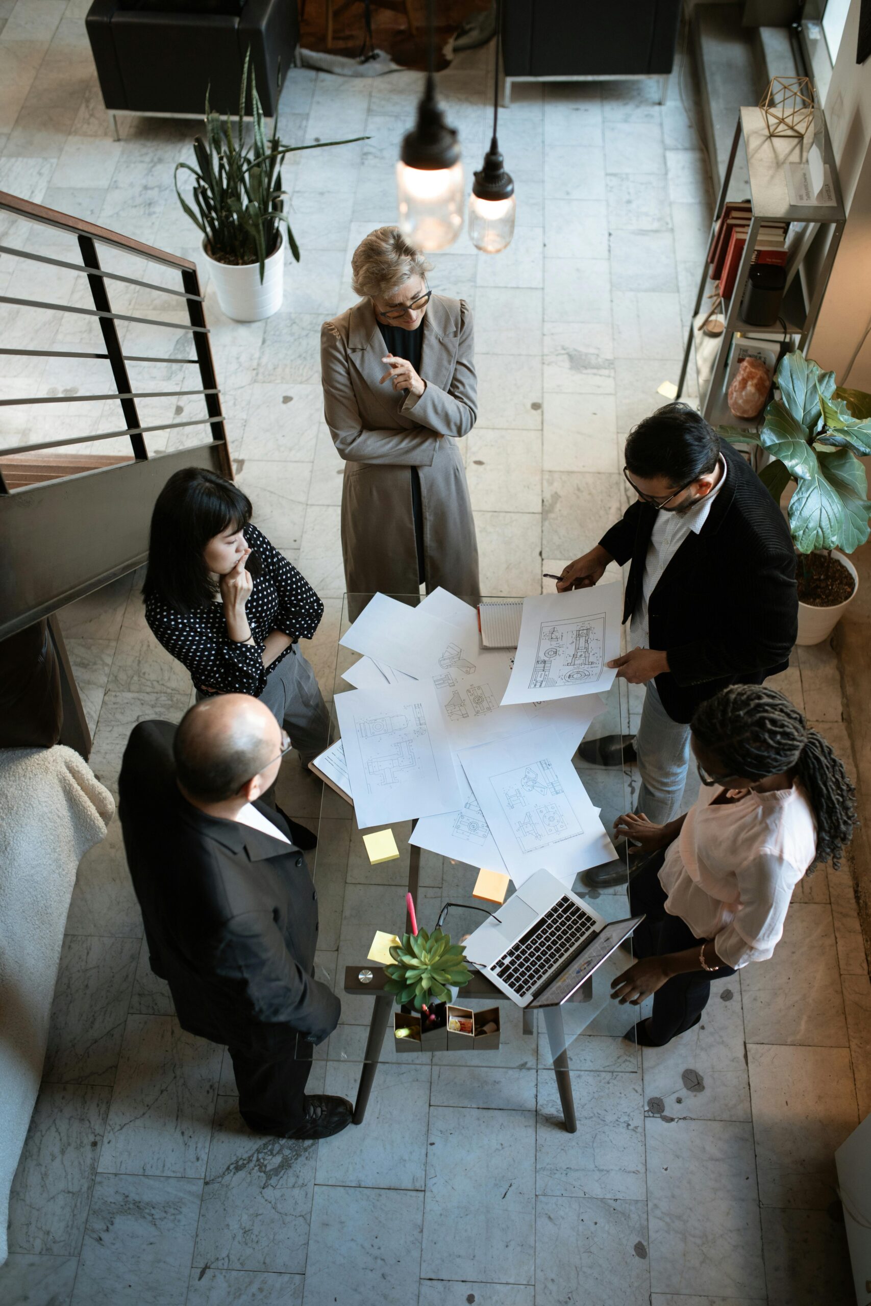 Team in discussion around project plans in a modern office setting